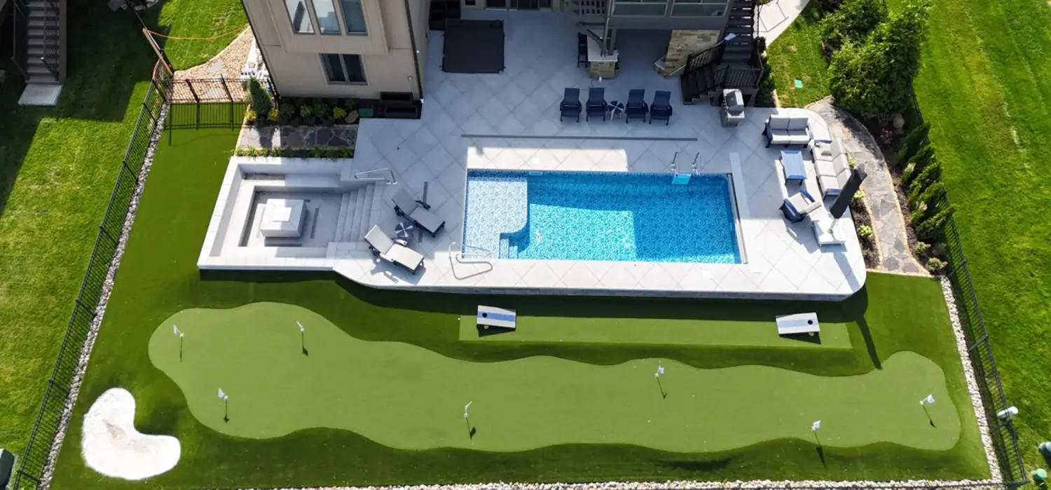 Backyard pool area & putting green installed by SYNLawn